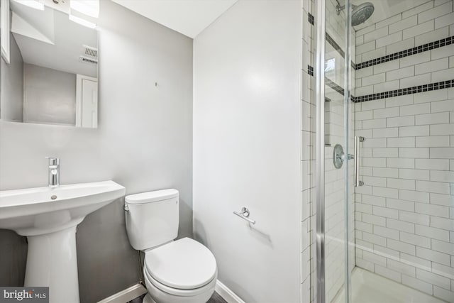 full bathroom featuring baseboards, a shower stall, and toilet