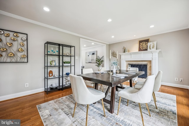 dining area with crown molding, baseboards, recessed lighting, and wood finished floors