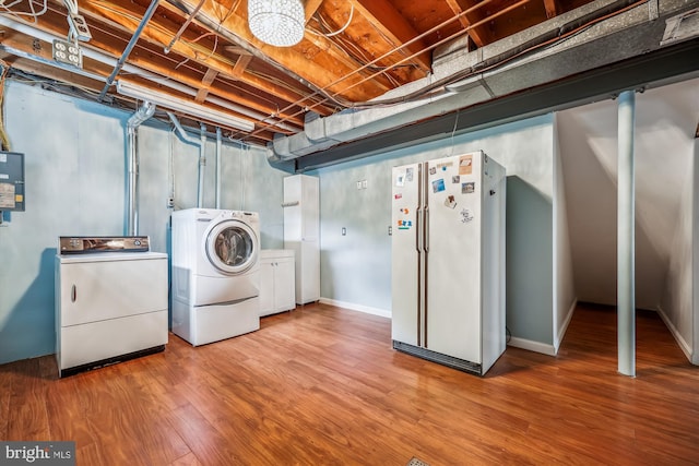 clothes washing area featuring laundry area, independent washer and dryer, wood finished floors, and electric panel