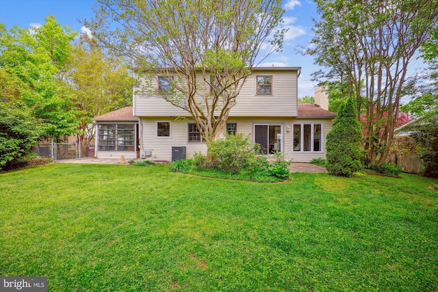 rear view of house featuring fence, a patio, and a lawn