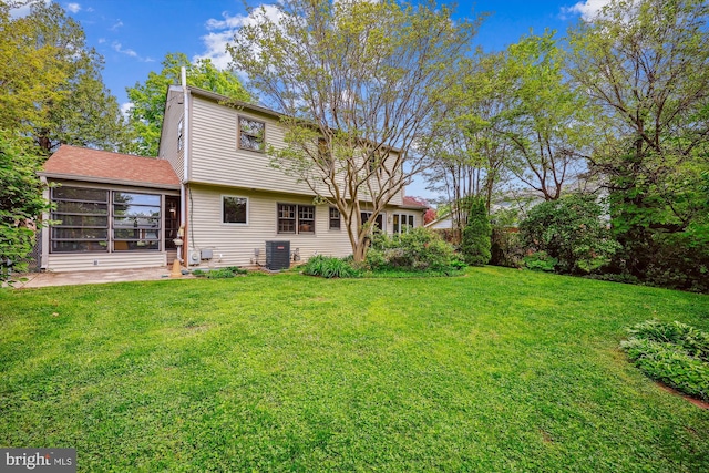 back of property featuring a yard, a sunroom, and central air condition unit