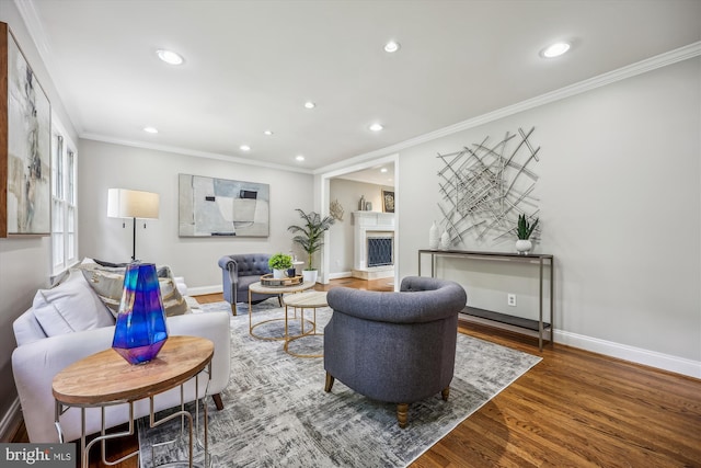 living area with crown molding, recessed lighting, baseboards, and wood finished floors