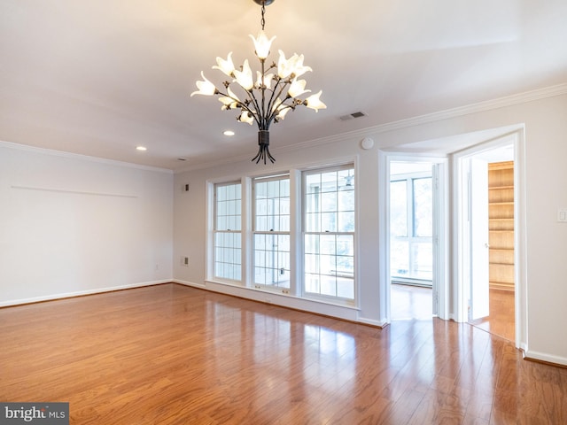 spare room with ornamental molding and light hardwood / wood-style floors