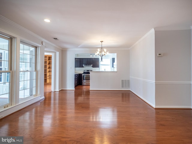 unfurnished living room featuring an inviting chandelier, ornamental molding, and dark hardwood / wood-style floors