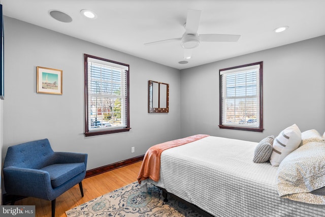 bedroom featuring multiple windows, wood-type flooring, and ceiling fan