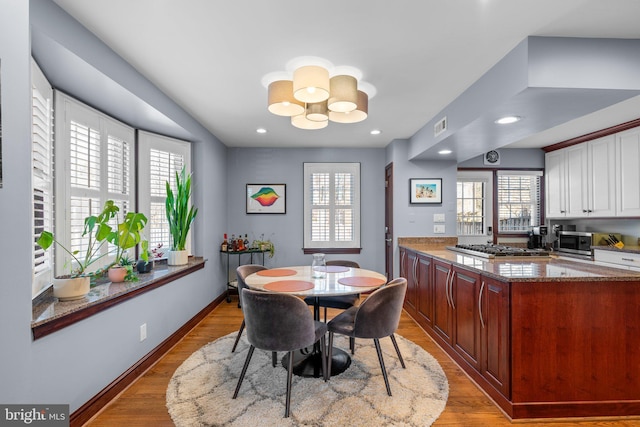 dining room with a notable chandelier and light wood-type flooring