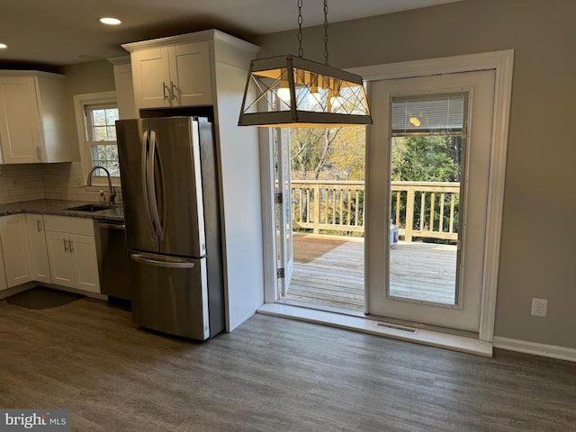 kitchen with dark hardwood / wood-style floors, decorative light fixtures, sink, white cabinets, and stainless steel appliances