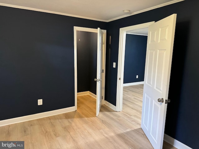 unfurnished room featuring crown molding and light hardwood / wood-style flooring