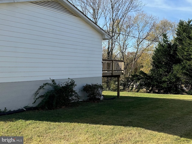 view of home's exterior with a wooden deck and a lawn