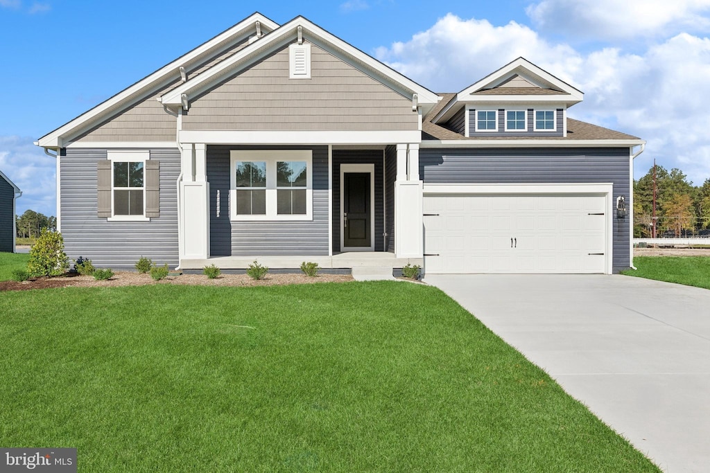 craftsman inspired home with a garage and a front yard