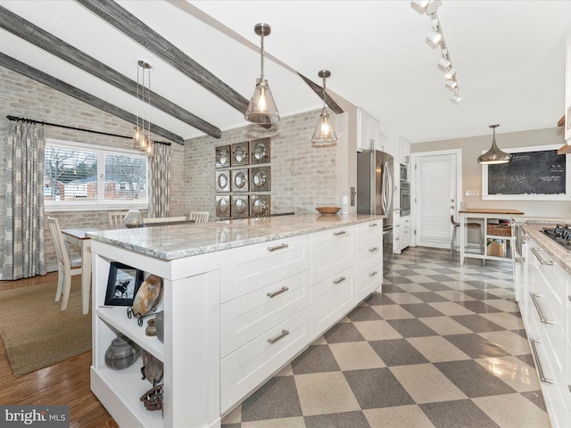 kitchen featuring white cabinetry, brick wall, decorative light fixtures, and light stone countertops