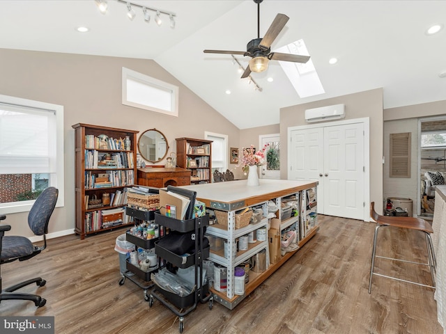 home office with ceiling fan, hardwood / wood-style floors, a skylight, high vaulted ceiling, and a wall unit AC