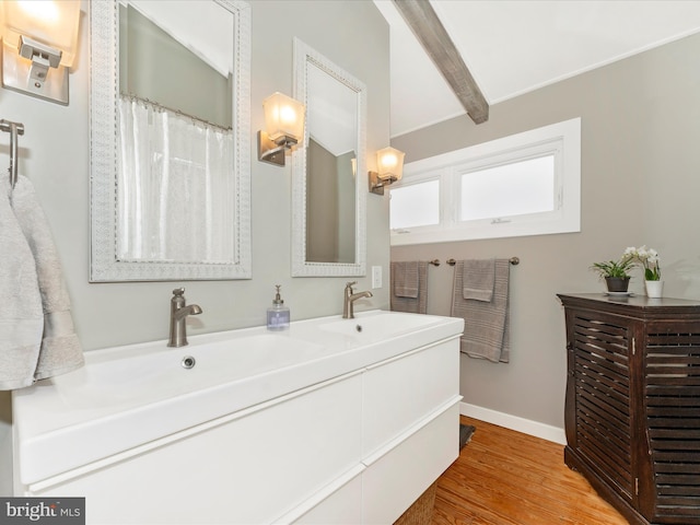 bathroom featuring vanity, hardwood / wood-style flooring, and beamed ceiling