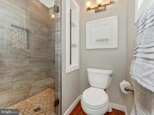 bathroom featuring toilet, an enclosed shower, and hardwood / wood-style floors