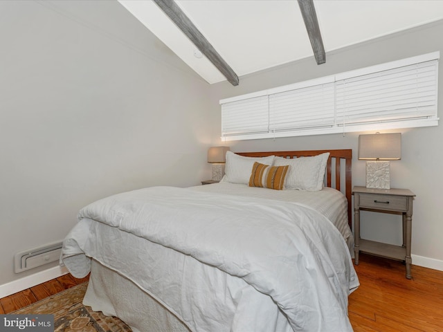 bedroom with vaulted ceiling with beams and wood-type flooring