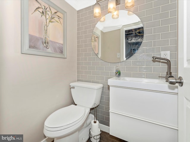 bathroom featuring tasteful backsplash, vanity, toilet, and tile walls