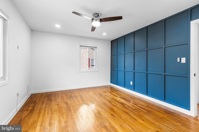 spare room with ceiling fan and light wood-type flooring