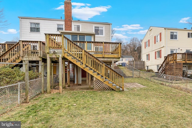 rear view of property with a deck and a lawn