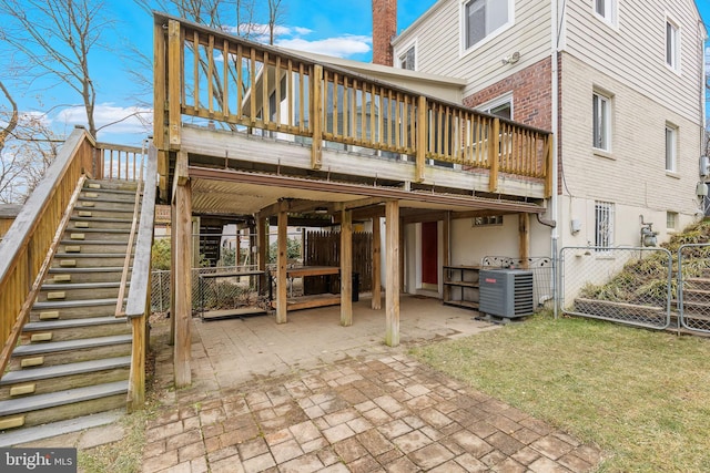 back of house featuring a lawn, a deck, a patio, and central air condition unit