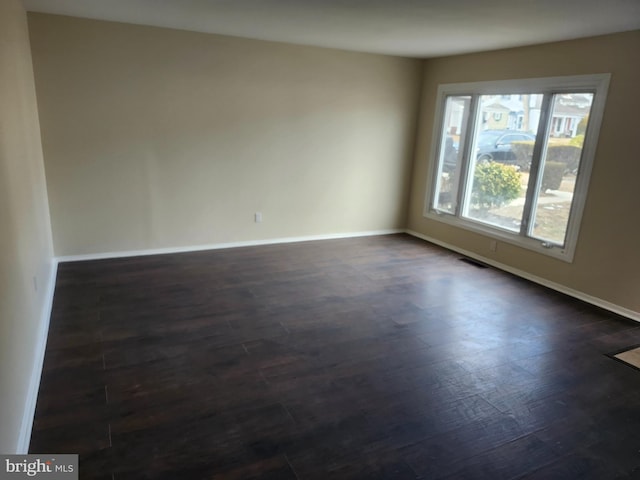 spare room featuring dark wood-type flooring