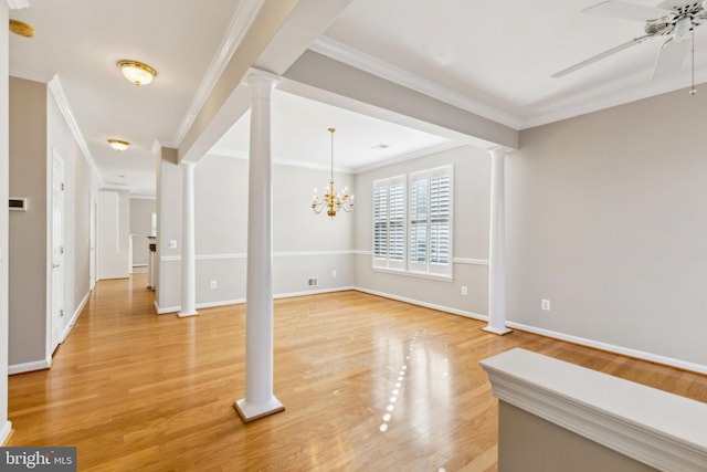 interior space with ceiling fan with notable chandelier, ornamental molding, wood-type flooring, and decorative columns