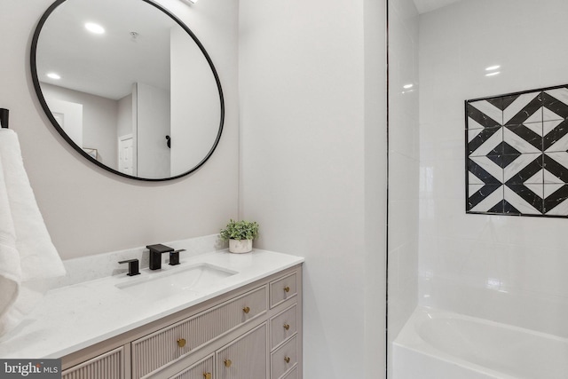 bathroom featuring tiled shower / bath and vanity