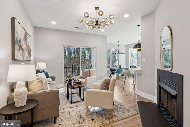 living room with a notable chandelier and light wood-type flooring