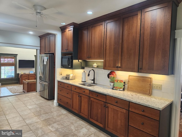 kitchen featuring freestanding refrigerator, a sink, a ceiling fan, and backsplash