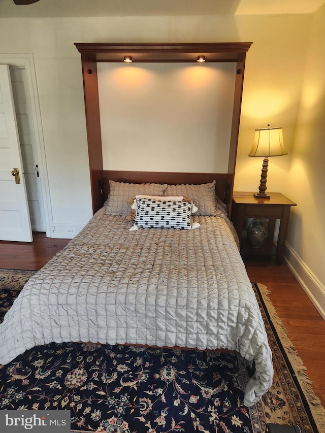 bedroom featuring baseboards and wood finished floors