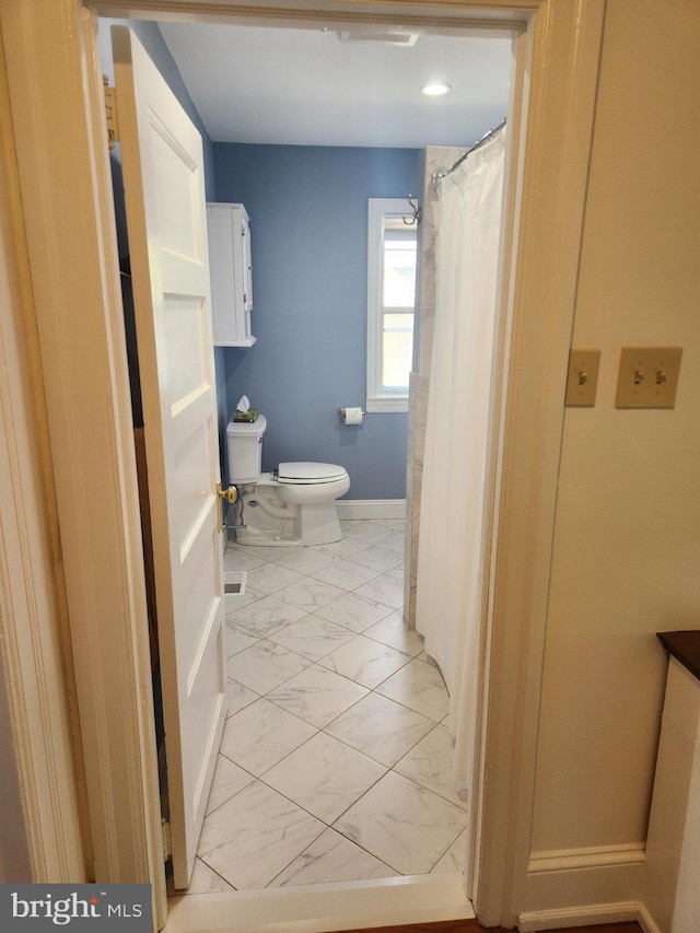 bathroom featuring toilet, baseboards, visible vents, and marble finish floor