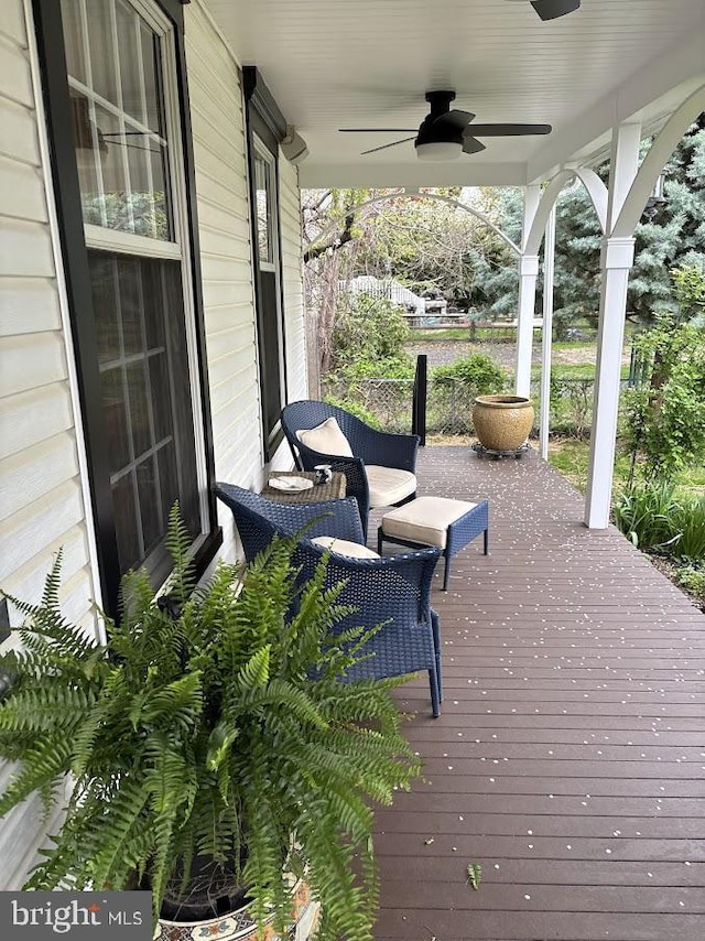 wooden terrace featuring a porch and a ceiling fan