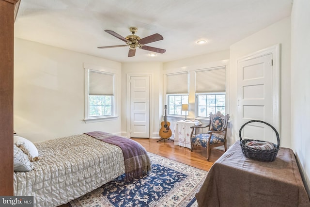 bedroom featuring a ceiling fan, recessed lighting, multiple windows, and wood finished floors