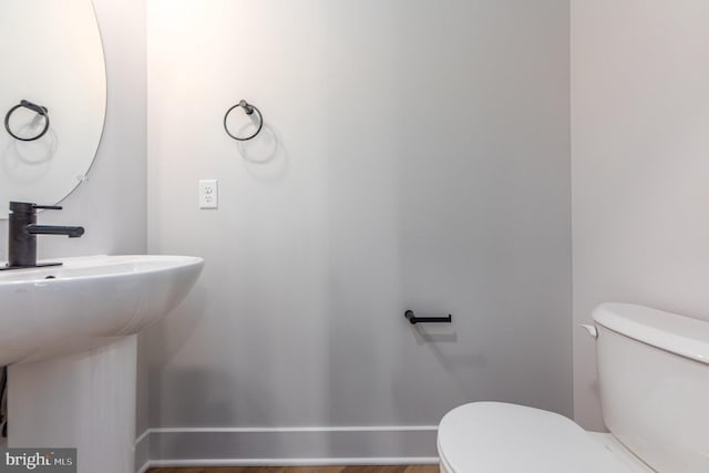 bathroom featuring toilet, sink, and hardwood / wood-style floors