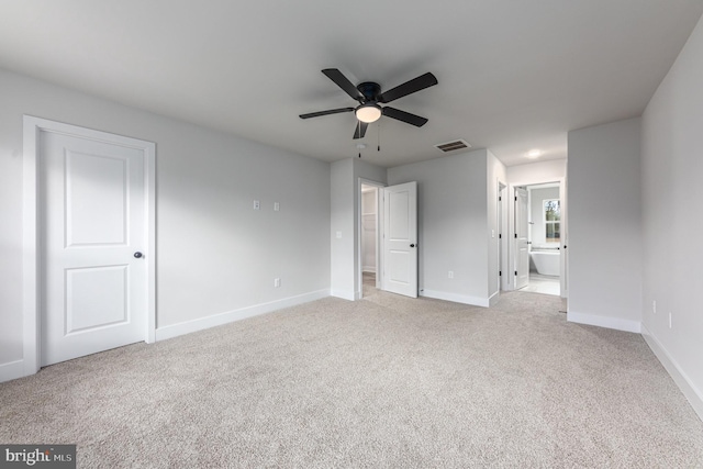 unfurnished bedroom with connected bathroom, light colored carpet, and ceiling fan