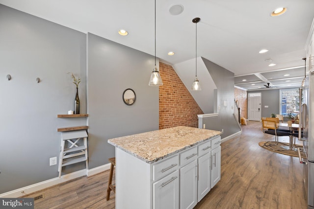 kitchen featuring wood finished floors, white cabinetry, and a center island