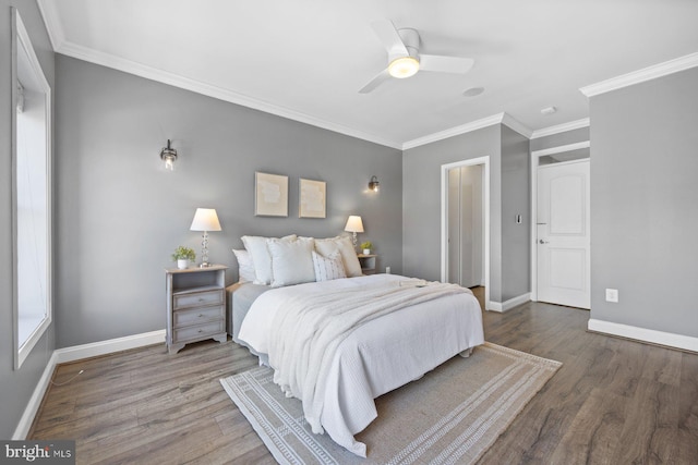 bedroom with a ceiling fan, crown molding, baseboards, and wood finished floors