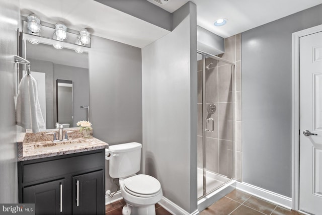 bathroom with a stall shower, baseboards, tile patterned flooring, and toilet