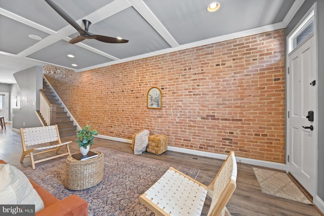 interior space featuring stairway, brick wall, wood finished floors, coffered ceiling, and baseboards