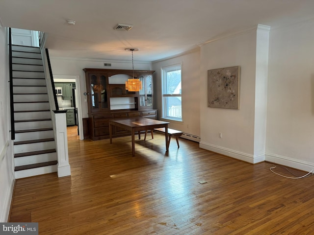 dining area featuring dark wood-type flooring and ornamental molding