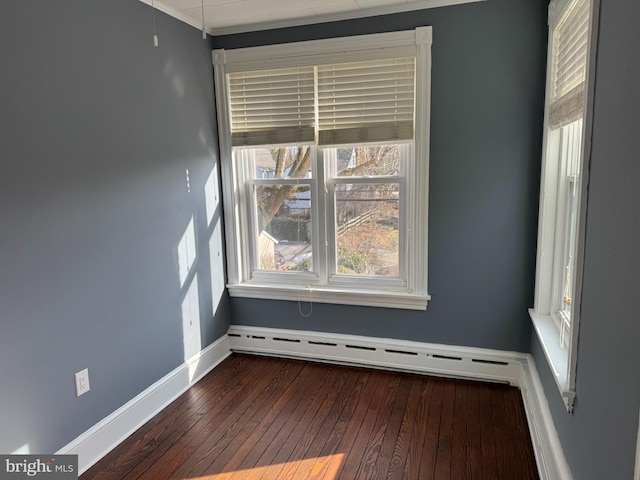 empty room featuring a baseboard radiator and dark hardwood / wood-style floors