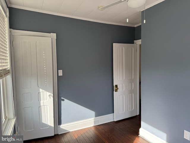 unfurnished bedroom with crown molding, dark wood-type flooring, and ceiling fan