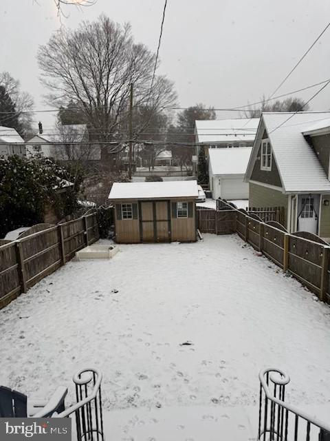 yard layered in snow featuring an outbuilding