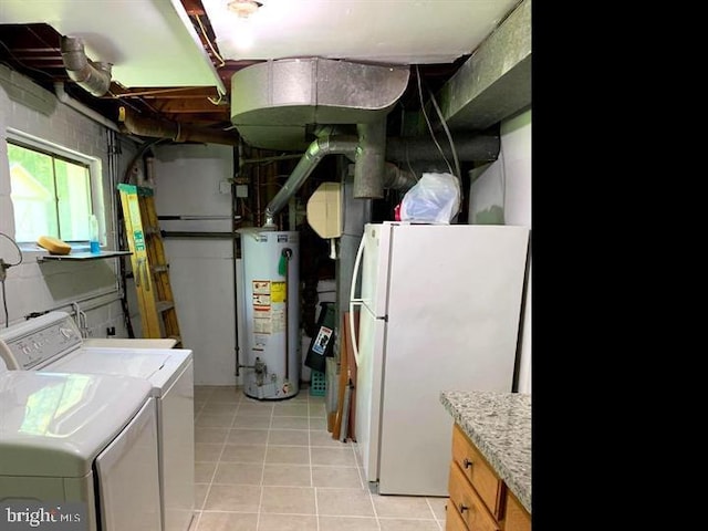 clothes washing area featuring light tile patterned flooring, separate washer and dryer, and water heater