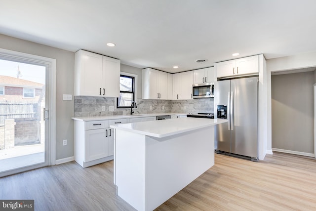 kitchen featuring stainless steel appliances, white cabinetry, and sink