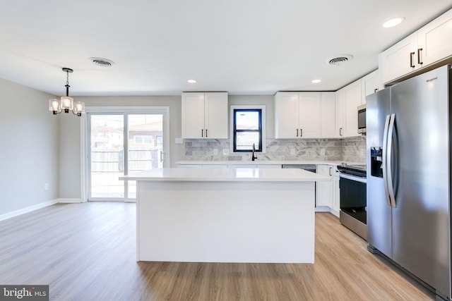 kitchen with stainless steel appliances, a center island, and white cabinets