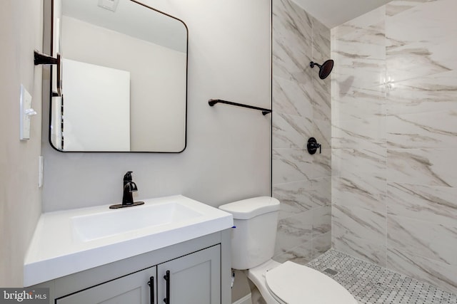 bathroom with vanity, a tile shower, and toilet