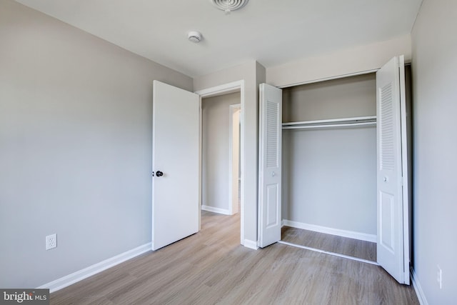 unfurnished bedroom with a closet and light hardwood / wood-style flooring