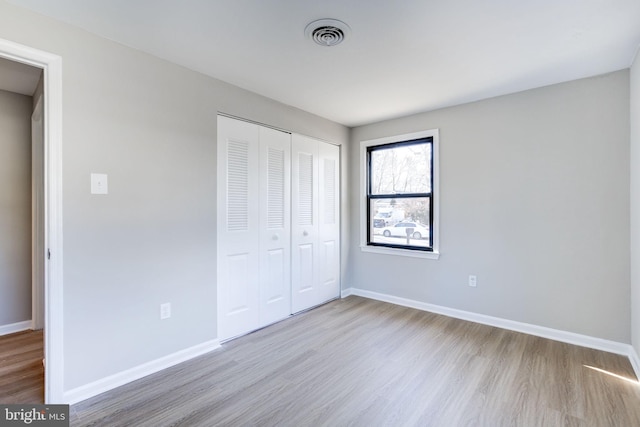 unfurnished bedroom featuring a closet and light wood-type flooring