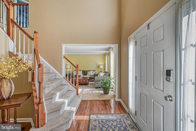 foyer with a towering ceiling and light hardwood / wood-style flooring