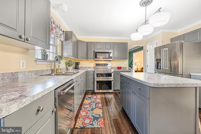 kitchen featuring pendant lighting, sink, gray cabinets, appliances with stainless steel finishes, and a kitchen island